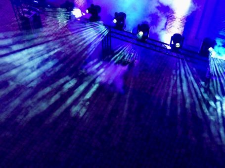 Bunte Lichter mit mystischen Strahlen auf einer dunklen Bühne.